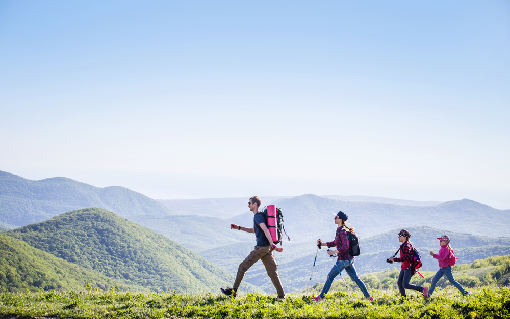 Family,With,Two,Kids,Have,Hiking,Through,The,Mountains